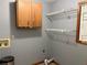 Functional laundry room with shelving, cabinet storage, and utility connections at 2181 Rodao Sw Dr, Lilburn, GA 30047