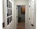 Hallway view of laundry room featuring tile flooring and simple fixtures and door access at 2181 Rodao Sw Dr, Lilburn, GA 30047