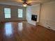 Bright and airy living room features a white brick fireplace and gleaming hardwood floors at 2181 Rodao Sw Dr, Lilburn, GA 30047