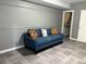 Cozy carpeted living room with a blue couch and bright, patterned pillows at 2181 Rodao Sw Dr, Lilburn, GA 30047