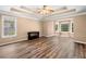Spacious bedroom with tray ceiling, fan, hardwood floors, and natural light at 405 Maple Rdg, White, GA 30184