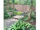 Idyllic backyard stream with a quaint bridge and shaded seating area at 1884 Whitehawk Ct, Lawrenceville, GA 30043
