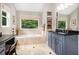 Bright bathroom featuring a large soaking tub beneath a picture window at 1884 Whitehawk Ct, Lawrenceville, GA 30043