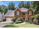 Charming brick two-story home featuring a well-manicured lawn and attached two-car garage at 1884 Whitehawk Ct, Lawrenceville, GA 30043