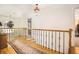 Elegant hallway with hardwood floors, wrought iron railings, and tasteful decor, connecting different areas of the home at 1884 Whitehawk Ct, Lawrenceville, GA 30043