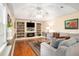 Living room showcasing built-in bookshelves, a fireplace, a large TV, and hardwood floors at 1884 Whitehawk Ct, Lawrenceville, GA 30043