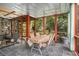 Inviting screened porch with slate floors and wooded view is perfect for outdoor dining at 1884 Whitehawk Ct, Lawrenceville, GA 30043