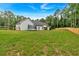Large, grassy backyard with a trampoline, framed by a wooden fence and a bright blue sky at 3088 Hiram Sudie Road, Hiram, GA 30141