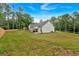 A sprawling backyard with a green lawn, newly built fence, and a modern farmhouse-style home at 3088 Hiram Sudie Road, Hiram, GA 30141