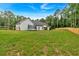 Large grassy backyard featuring a trampoline, a wooden fence, and mature trees at 3088 Hiram Sudie Road, Hiram, GA 30141