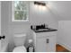 Bathroom featuring a vanity with black countertop, white cabinets, toilet, and shower at 3088 Hiram Sudie Road, Hiram, GA 30141