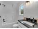 Bathroom with black hardware, modern lighting, and white tub-shower combo at 3088 Hiram Sudie Road, Hiram, GA 30141