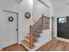 Inviting entryway featuring beautiful hardwood floors, natural light, and stylish staircase at 3088 Hiram Sudie Road, Hiram, GA 30141
