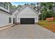 Exterior detached garage with a black garage door and gravel driveway, adjacent to a well-maintained yard at 3088 Hiram Sudie Road, Hiram, GA 30141