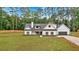 Picturesque white farmhouse with dark shutters, an attached garage, and a spacious green lawn at 3088 Hiram Sudie Road, Hiram, GA 30141