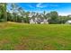 Two-story white farmhouse with black trim and wood shutters surrounded by a large green lawn and woods at 3088 Hiram Sudie Road, Hiram, GA 30141