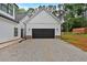 An attached two-car garage with a gravel driveway and a dark-colored door for a modern aesthetic at 3088 Hiram Sudie Road, Hiram, GA 30141