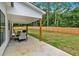Covered outdoor patio with a tranquil view of the large, fenced-in backyard at 3088 Hiram Sudie Road, Hiram, GA 30141