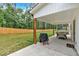 Relaxing outdoor patio with a barbecue and view of the spacious, fenced backyard at 3088 Hiram Sudie Road, Hiram, GA 30141