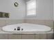 Bathroom featuring a triangular jacuzzi-style bathtub with a tile surround at 3835 Clearwater Dr, Atlanta, GA 30349