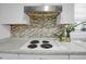 Well-lit kitchen with an electric cooktop and charming backsplash at 3835 Clearwater Dr, Atlanta, GA 30349