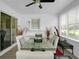 Bright sunroom features a glass top dining table, white paneling, and large windows offering outdoor views at 3835 Clearwater Dr, Atlanta, GA 30349