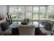 Sunroom featuring large windows with blinds, a glass dining table, and neutral decor at 3835 Clearwater Dr, Atlanta, GA 30349