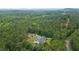 An aerial view shows a lovely home with an above ground pool surrounded by a lush green forest at 188 Macedonia Rd, White, GA 30184