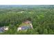 An aerial shot displays a home with an above ground pool, nestled amidst a vibrant, dense forest at 188 Macedonia Rd, White, GA 30184