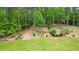 A serene backyard featuring a walking path is framed by a lush green lawn and a vibrant forest at 188 Macedonia Rd, White, GA 30184
