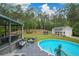 Inviting backyard with an above-ground pool, spacious deck area, lush landscaping, and a charming outbuilding at 188 Macedonia Rd, White, GA 30184