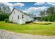 Exterior view of the home showcasing the spacious lawn, neat landscaping, and side facade of the house at 188 Macedonia Rd, White, GA 30184