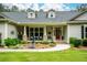 Welcoming front porch with a red door, rocking chairs, and beautifully landscaped garden at 188 Macedonia Rd, White, GA 30184