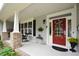Inviting front porch with a red door, rocking chairs, and a well-decorated entrance at 188 Macedonia Rd, White, GA 30184