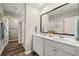 Bright bathroom featuring a double sink vanity with a large framed mirror and a glass shower at 1911 Colestock Se Ave, Conyers, GA 30094