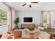 Light-filled living room boasts modern furniture, hardwood floors and backyard views at 1911 Colestock Se Ave, Conyers, GA 30094