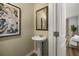 Elegant powder room featuring a pedestal sink, decorative mirror, and neutral wall color at 1911 Colestock Se Ave, Conyers, GA 30094