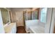 Bright bathroom with a glass-enclosed shower, soaking tub, and wood-look flooring at 1961 Ecoland Dr, Grayson, GA 30017