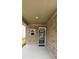 Covered porch with brick pillars and siding, a small window, and a dark front door with glass at 1961 Ecoland Dr, Grayson, GA 30017
