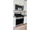Stainless steel stove and microwave with white cabinetry and granite countertops at 1961 Ecoland Dr, Grayson, GA 30017