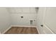 A small laundry room features wood floors, utility connections, and a wire shelf at 1961 Ecoland Dr, Grayson, GA 30017