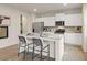 Bright kitchen boasts white cabinets, stainless appliances, granite counters, and a center island with stool seating at 8502 Polston Lot 144 Pl, Douglasville, GA 30134