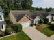 Aerial view of a well-maintained home with a two-car garage and landscaped yard at 414 Norton Xing, Woodstock, GA 30188