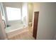 Bathroom with soaking tub under window plus a separate toilet room with dark brown door at 414 Norton Xing, Woodstock, GA 30188