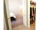 View into carpeted bedroom featuring a closet with clothes rack and an open door at 414 Norton Xing, Woodstock, GA 30188