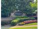 Community entrance sign with manicured landscaping and colorful flowerbeds at 414 Norton Xing, Woodstock, GA 30188