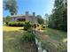 Serene backyard view featuring lush greenery and a brick home with a deck, perfect for outdoor enjoyment and relaxation at 4829 Moon Rd, Powder Springs, GA 30127