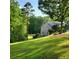 Well-maintained backyard featuring lush green grass and a brick home in the background at 4829 Moon Rd, Powder Springs, GA 30127