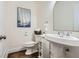 Charming powder room with pedestal sink, white trim, and hardwood floors at 4829 Moon Rd, Powder Springs, GA 30127