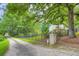 Gated entrance with brick pillars, a long gravel driveway lined with trees, and iron fence at 4829 Moon Rd, Powder Springs, GA 30127